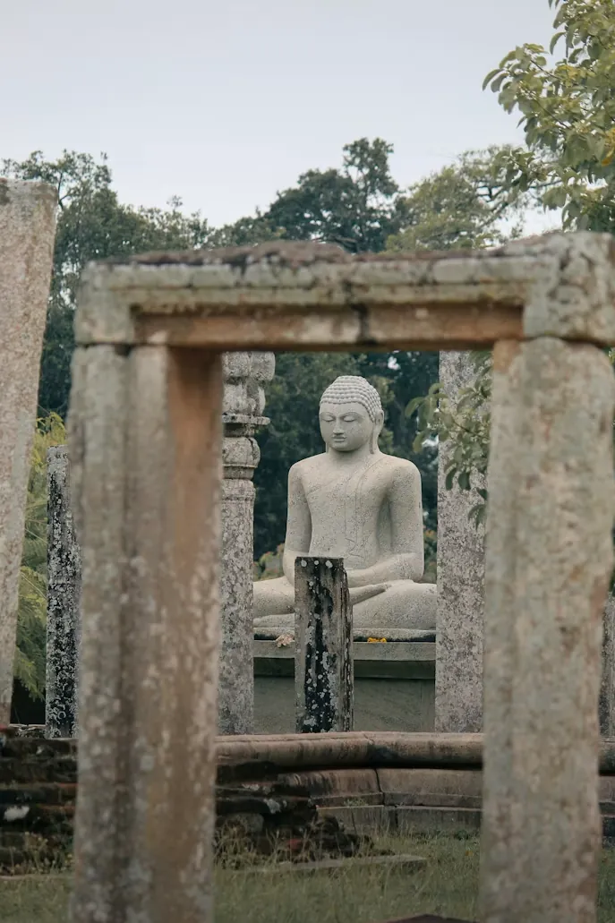 Seated Buddha statue within stone pillars at Thuparamaya