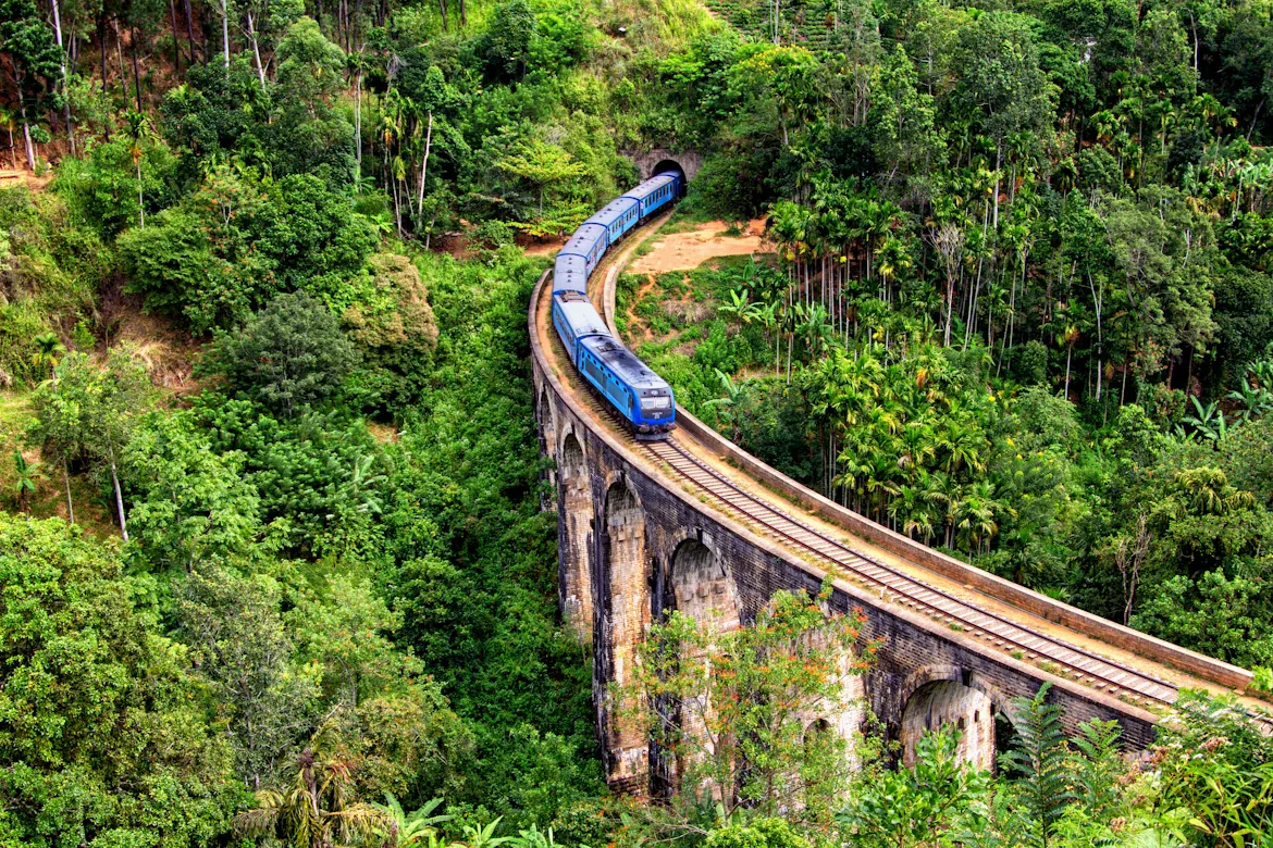 Blue train curving across Nine Arch Bridge in Ella, Sri Lanka